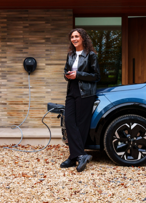 women standing in front of car plugged into pod point ev charger