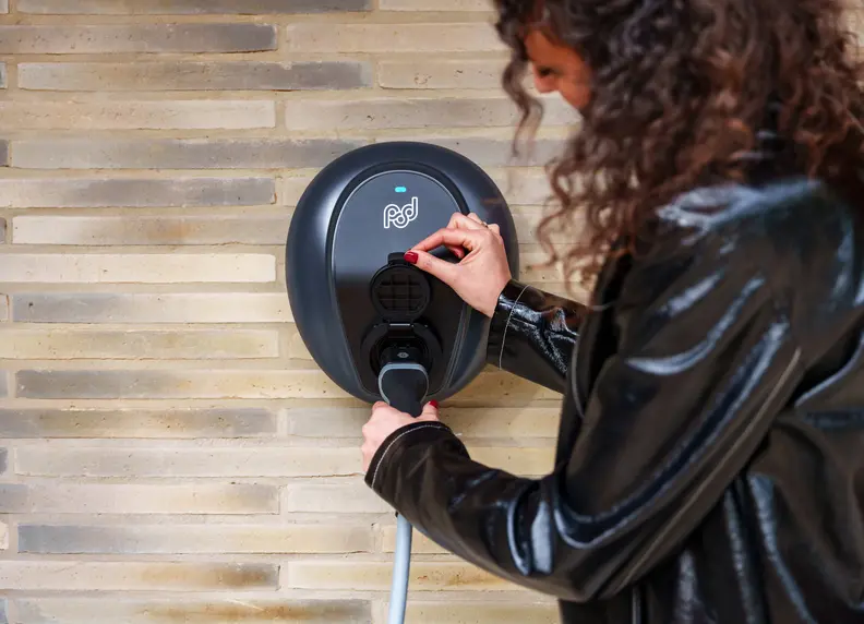 person plugging cable into pod point