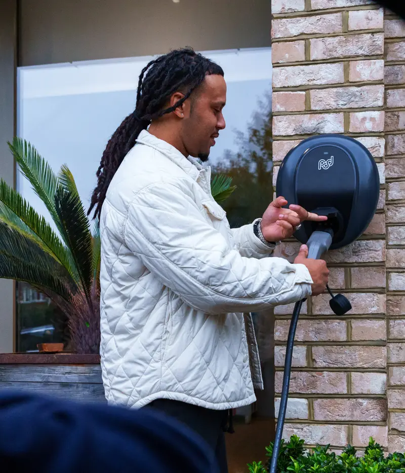 person plugging cable into pod point ev charger