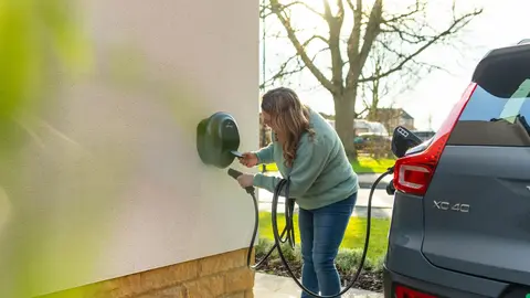 person plugging cable into Pod Point EV charger