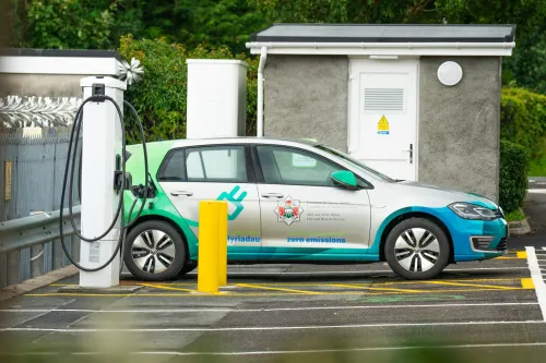 Side view of fire service car plugged into Pod Point velocity charger